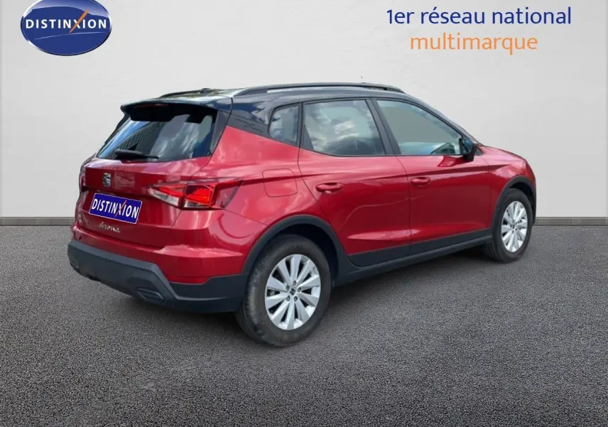 SEAT Arona rouge désir métal avec toit noir, vue 3/4 arrière côté droit sur fond neutre.