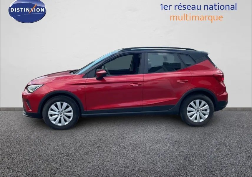 Profil droit d'un SEAT Arona 2025 rouge désir métal avec toit noir, roues alliage et vitres teintées.