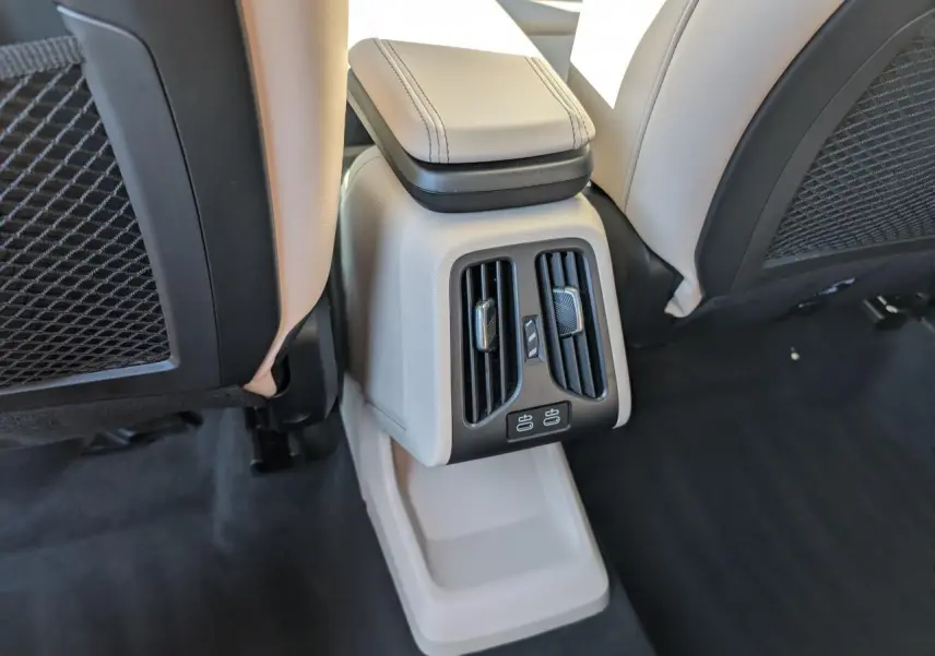 Détail de la console arrière beige avec aérateurs et ports USB du BMW X1 M Sport 2024 noir.