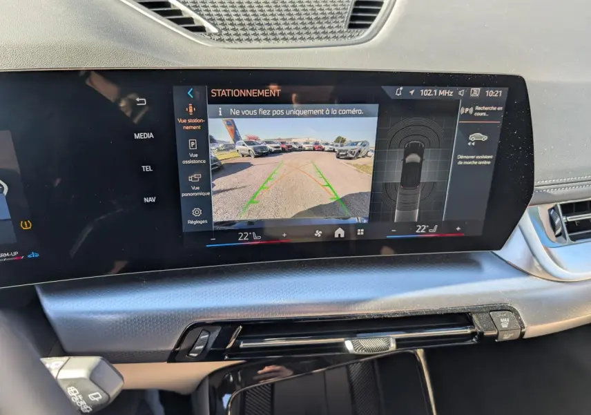 Écran tactile incurvé du tableau de bord du BMW X1 noir, affichant la caméra de recul en vue centrale.