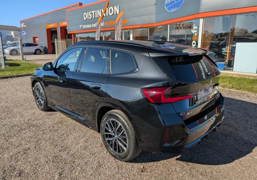 BMW X1 XDrive 20d M Sport noir 3/4 arrière droit, jantes alliage 18 pouces et feux LED arrière visibles.