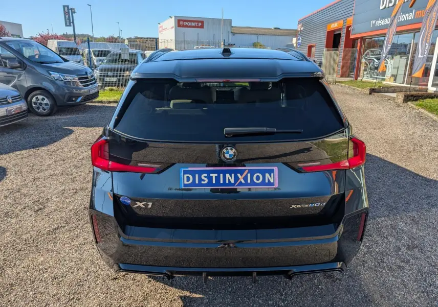 Vue arrière d’un BMW X1 noir métallisé avec feux LED horizontaux et logo BMW bien visible.