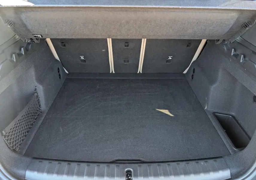 Coffre ouvert d'un BMW X1 noir, vue intérieure montrant un espace de chargement propre et bien fini.