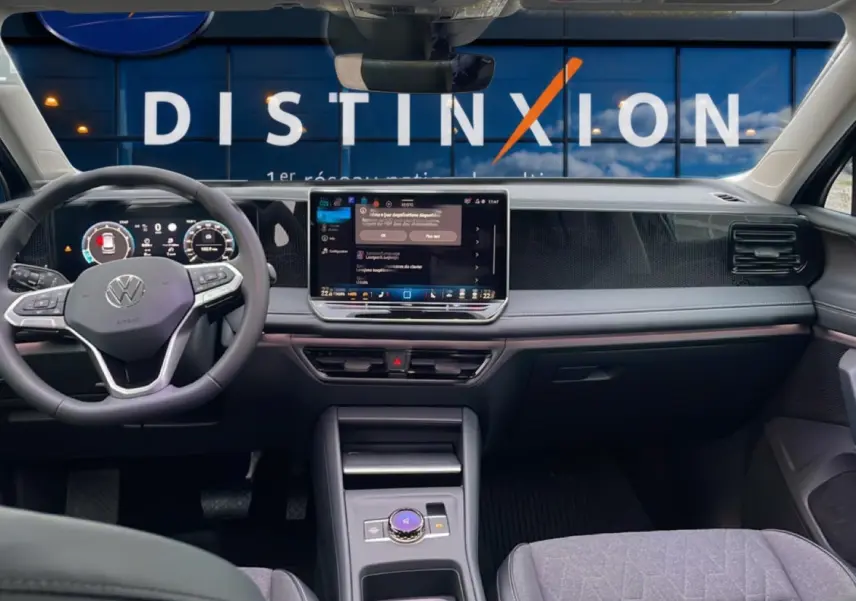 Vue intérieure avant du Volkswagen Tiguan 2025 noir, tableau de bord moderne avec écran tactile central et volant multifonction.