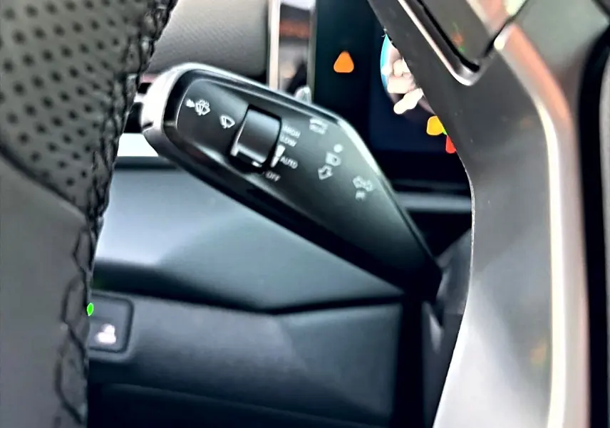 Gros plan sur la manette de commande des essuie-glaces du Volkswagen T-Roc 2026, intérieur noir et volant cuir.
