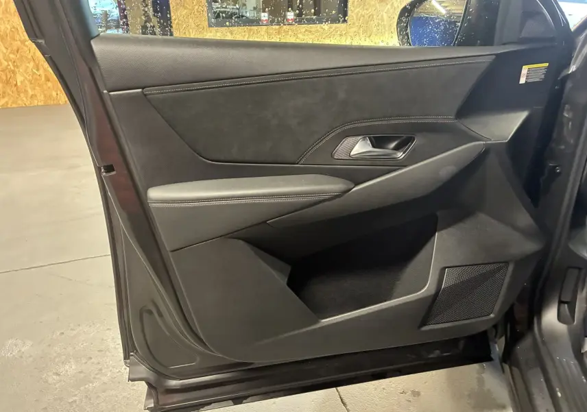 Vue intérieure côté gauche de la porte avant gris foncé du DS7 E-TENSE avec garniture en cuir et insert tissu.