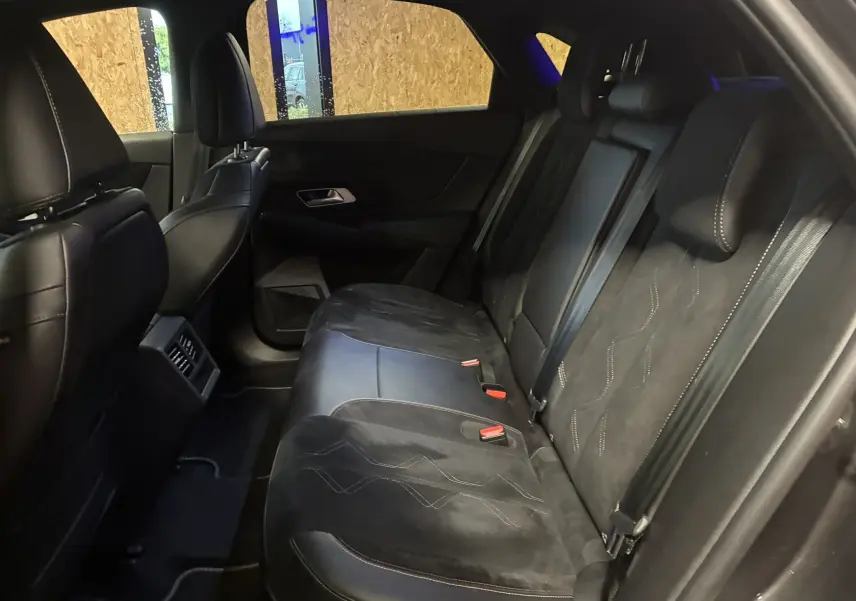 Vue intérieure de la banquette arrière en cuir noir du DS7 E-TENSE 2024, avec ceintures et appuie-têtes visibles.
