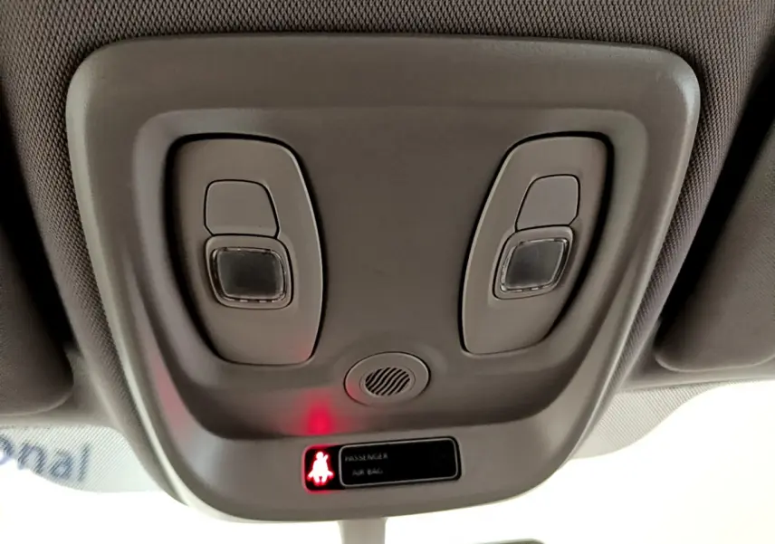 Plafonnier intérieur gris clair avec commandes d’éclairage et témoin airbag passager allumé dans un Renault Captur 2018.
