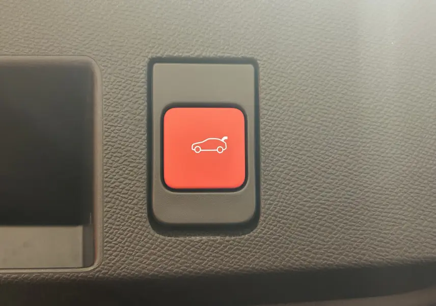 Bouton rouge d'ouverture du coffre sur tableau de bord texturé du Citroën C5 Aircross II Hybrid 2026.