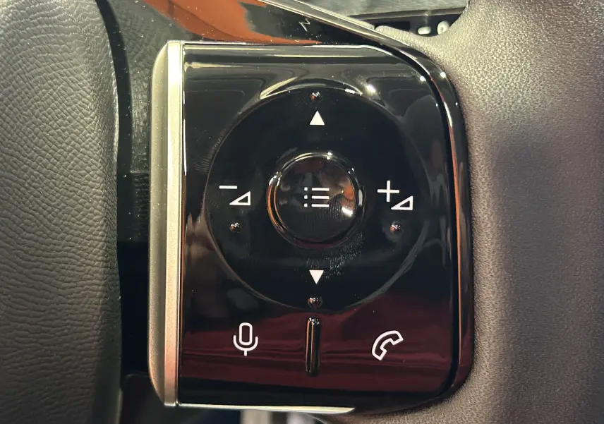 Gros plan sur les commandes vocales et téléphone sur le volant du Citroën C5 Aircross gris Platinium, version hybride 2026.