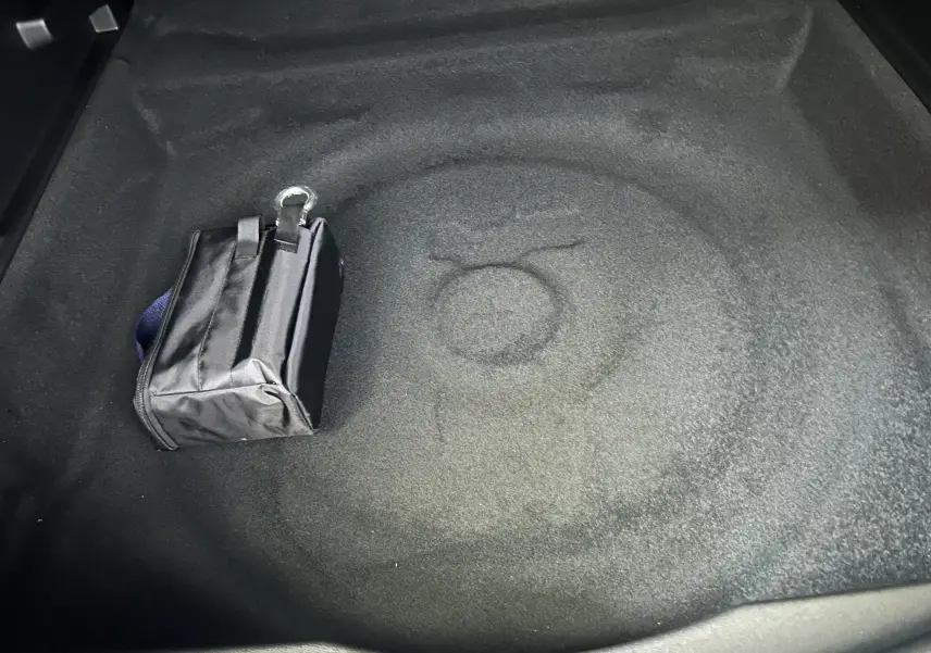 Coffre vide du Citroën C5 Aircross gris Platinium avec un petit sac noir posé, vue intérieure depuis l'arrière.