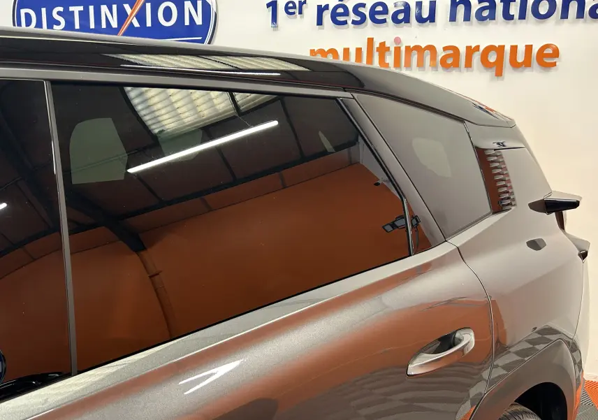 Vue côté droit arrière du Citroën C5 Aircross gris Platinium avec toit noir et vitres teintées.