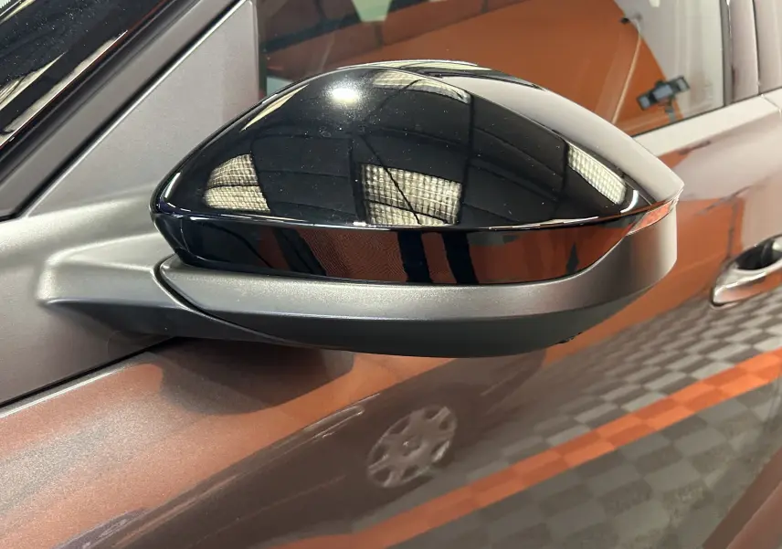 Gros plan sur le rétroviseur noir brillant côté gauche du Citroën C5 Aircross II Max Hybrid gris Platinium avec toit noir biton.