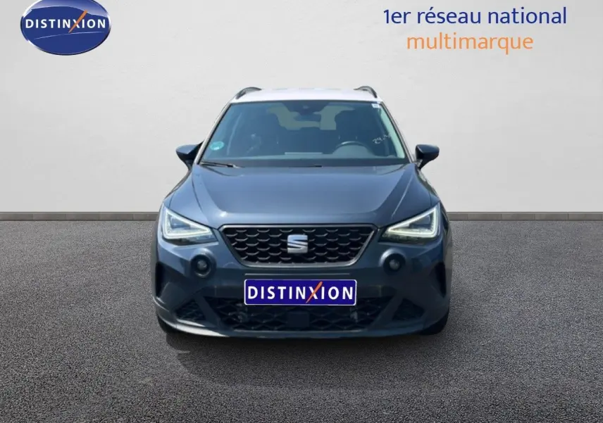 Vue frontale d'un SEAT Arona gris Magnetic avec toit blanc, mettant en valeur sa calandre et ses phares LED.