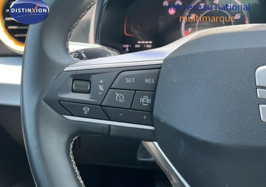 Gros plan sur le volant cuir noir du SEAT Arona 2025, montrant les commandes multifonctions côté gauche.