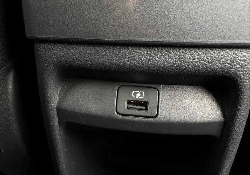 Prise USB de recharge intégrée dans la console centrale d'une Nissan Juke blanc perle 2024.