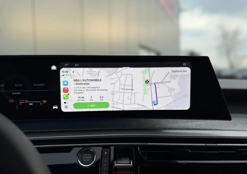 Vue intérieure du tableau de bord du Peugeot 3008 Hybrid 145 Allure 2025 avec écran panoramique incurvé affichant la navigation.