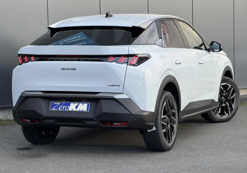 Vue 3/4 arrière droite du Peugeot 3008 Hybrid blanc Okénite avec feux arrière à LED 3 griffes et jantes alliage noires.