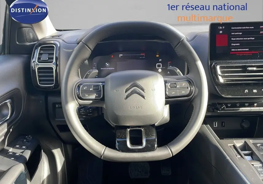 Vue centrée sur le volant cuir noir du Citroën C5 Aircross 2025 avec tableau de bord digital et écran tactile.