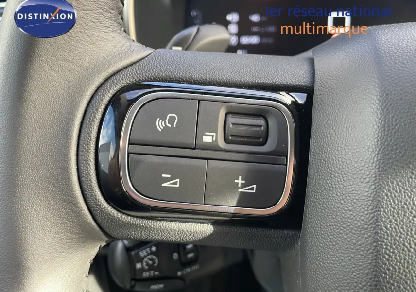 Gros plan sur les commandes de volume et téléphone au volant d’un Citroën C5 Aircross 2025, cuir noir.