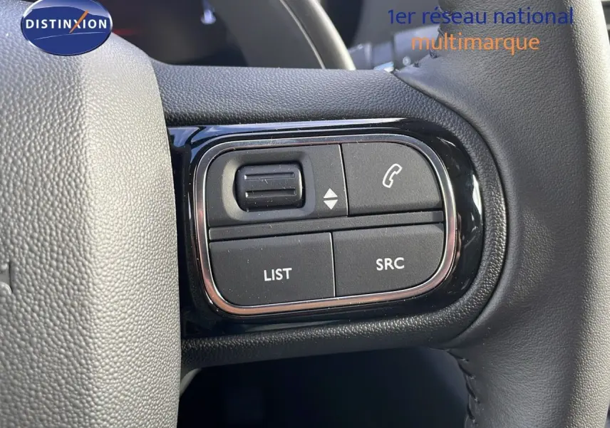 Gros plan sur les commandes au volant noir du Citroën C5 Aircross 2025, avec boutons de gestion d'appel et audio.