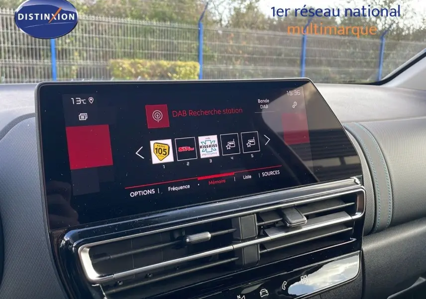 Écran tactile central avec interface DAB, tableau de bord en cuir noir et surpiqûres bleues dans un Citroën C5 Aircross.