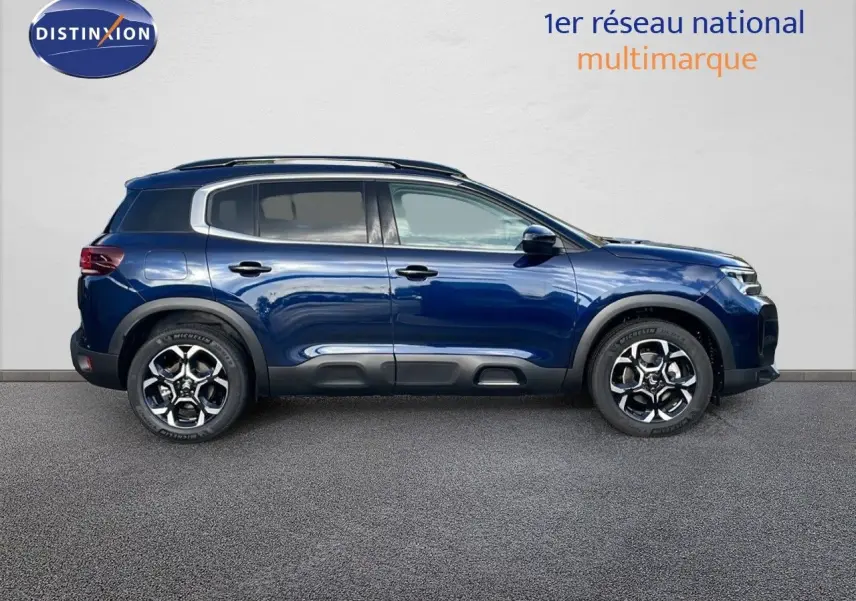 Profil droit du Citroën C5 Aircross 2025 en bleu eclipse métal, avec jantes alliage et protections noires sur les bas de caisse.