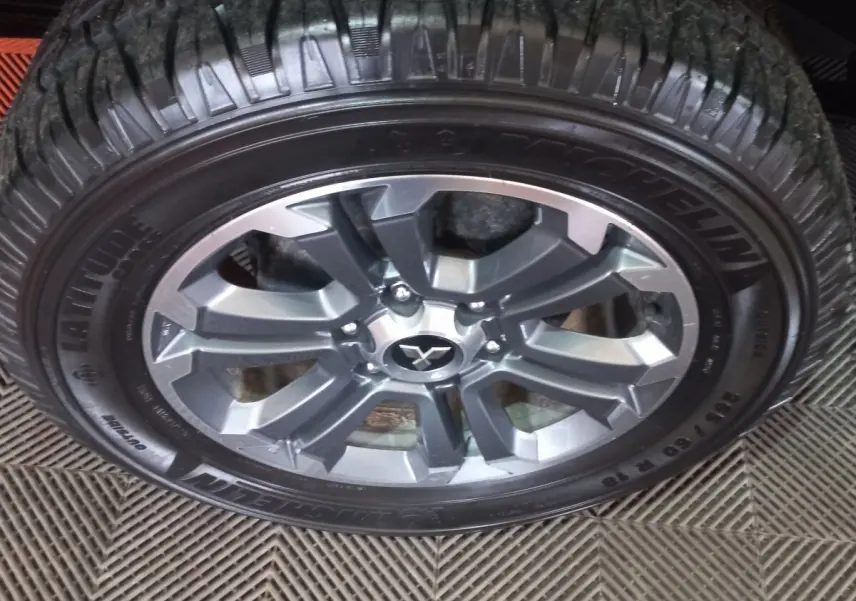 Gros plan sur la roue avant droite du Mitsubishi L200 gris foncé, avec jante alliage et pneu Michelin.
