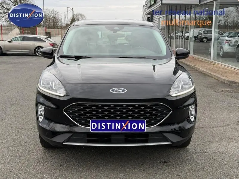 Vue frontale d'un Ford Kuga 1.5 EcoBoost 150ch Titanium 2024 noir, avec calandre hexagonale et phares LED distinctifs.