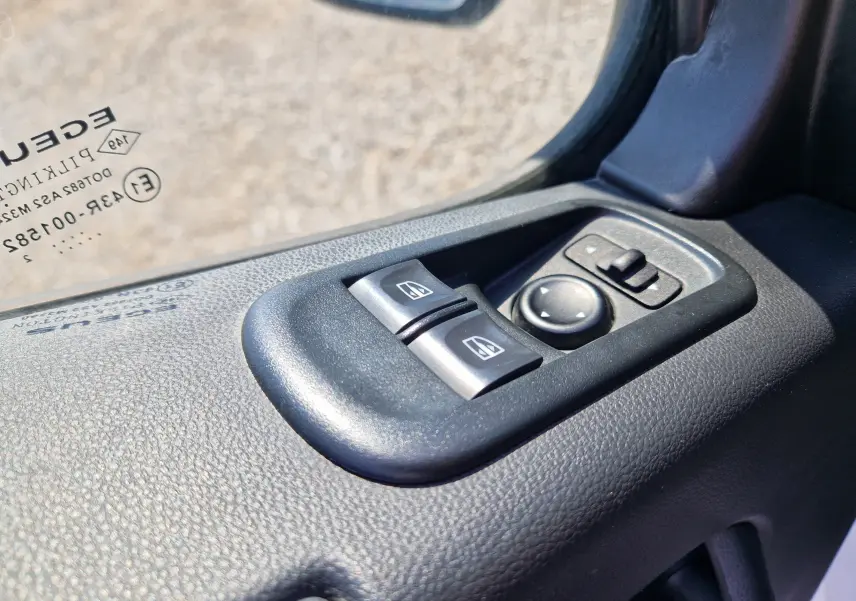 Gros plan sur les commandes des vitres électriques et rétroviseurs côté conducteur du Renault Master blanc 2022.
