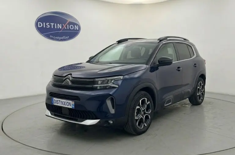 Citroën C5 Aircross hybride bleu foncé en 3/4 avant, avec jantes distinctives et toit noir, vue en studio.