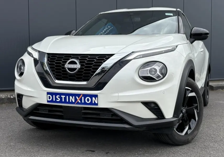 Nissan Juke blanc perle vu de face droite, avec calandre noire et jantes alliage noires distinctives.