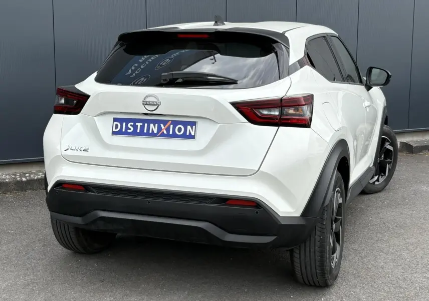 Vue 3/4 arrière droite du Nissan Juke blanc perle 2023 avec feux LED et jantes alliage noires.