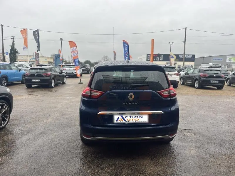 Vue arrière d'un Renault Grand Scenic bleu Cosmos 2022 sur un parking de concession automobile.