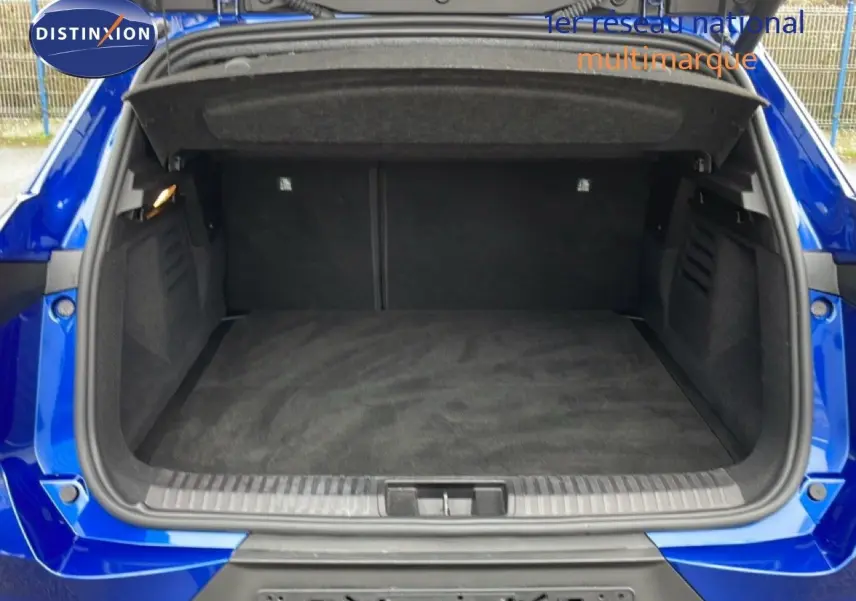 Coffre ouvert vu de l'arrière d'une Renault Symbioz bleu iron metal, montrant un espace de chargement propre et spacieux.
