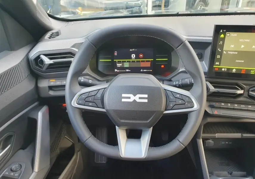 Vue intérieure centrée sur le volant multifonction et le tableau de bord digital du Dacia Duster 2026.