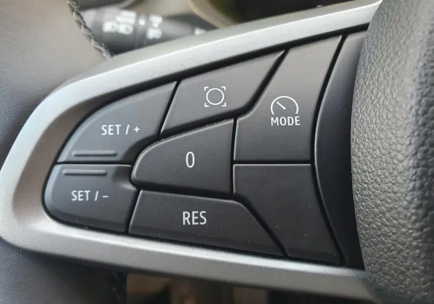 Gros plan sur les commandes au volant du Dacia Duster 2026, finition Journey, avec boutons de régulateur de vitesse.