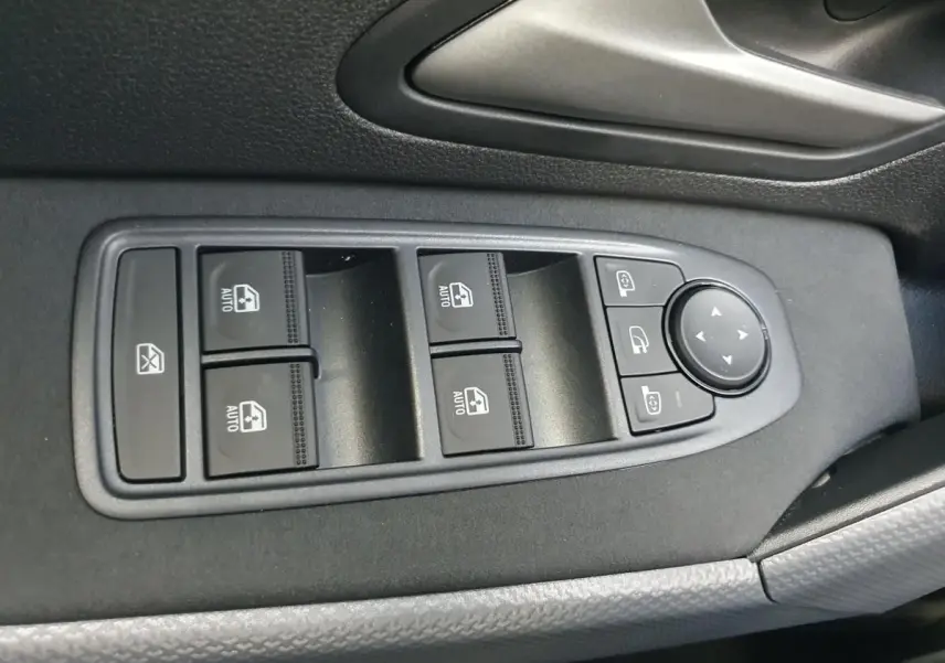 Commande des vitres électriques et réglages des rétroviseurs sur la porte côté conducteur du Dacia Duster 2026.