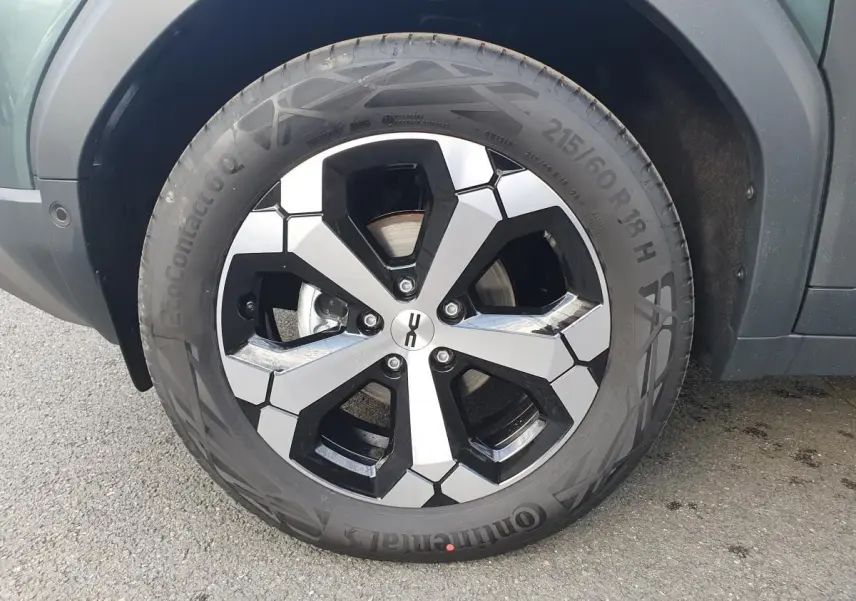 Gros plan sur la jante alliage 18” diamantée Tagasan du Dacia Duster vert cèdre, côté gauche arrière.