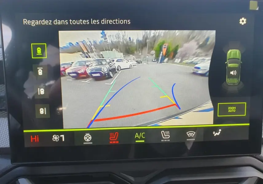 Écran de caméra de recul du Dacia Duster vert cèdre montrant l'arrière et les lignes de guidage colorées.