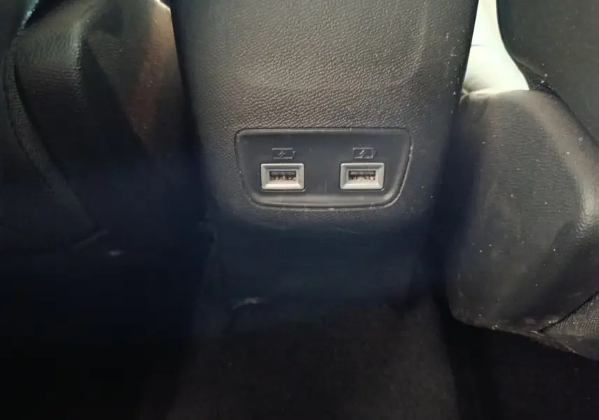 Prise double USB arrière sur console centrale noire dans l’habitacle d’une Peugeot 208 blanche 2021.