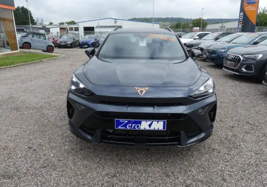 Vue avant d'un CUPRA Formentor gris magnétique avec logo cuivre et phares LED allumés sur parking.