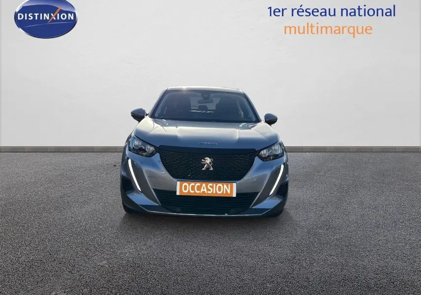 Vue frontale d'un Peugeot 2008 gris Artense avec calandre noire et feux LED, sur fond neutre avec panneau Distinxion.