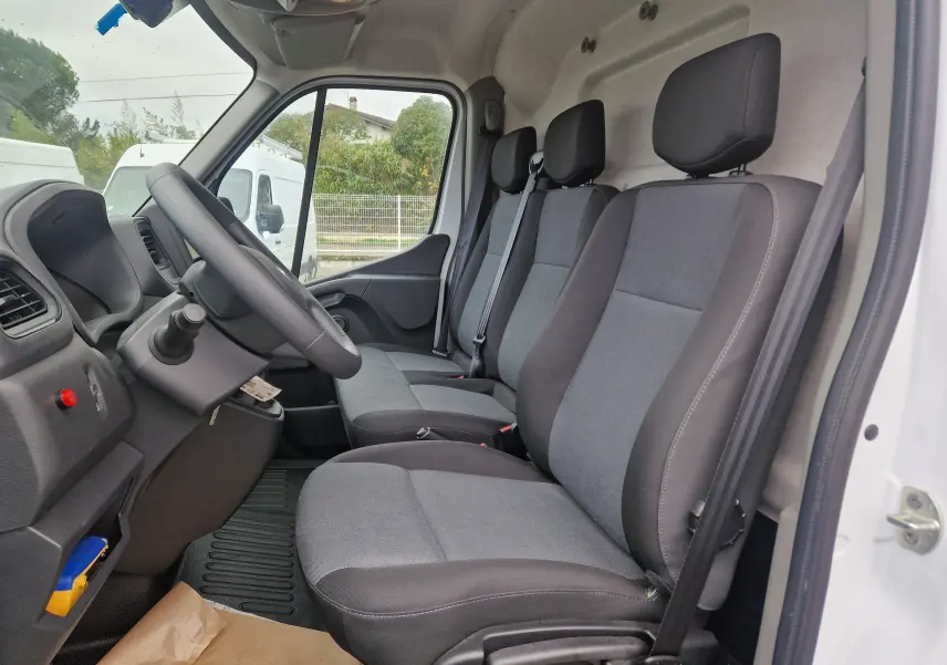 Intérieur du Renault Master blanc 2023, vue côté gauche sur les trois sièges avant en tissu gris et noir.