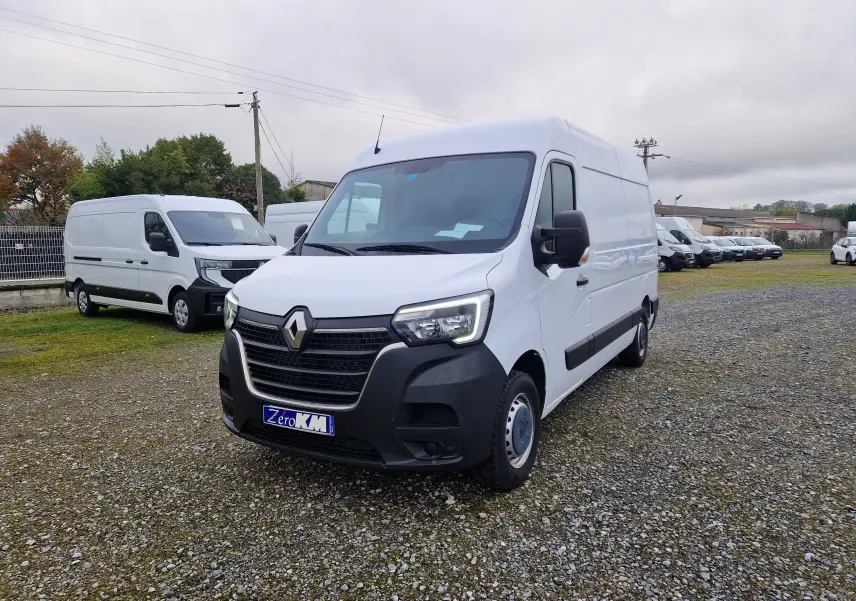 Renault Master blanc en 3/4 avant droit sur parking, avec calandre noire et hayon visible à l'arrière.