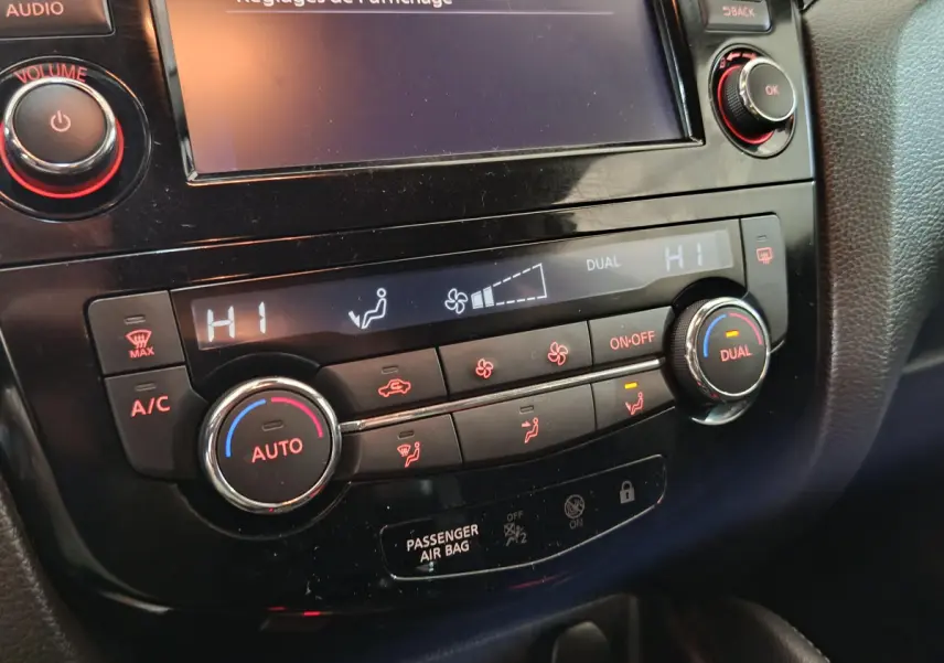 Gros plan sur la console centrale noire du Nissan Qashqai 2019, montrant les commandes de climatisation digitale.