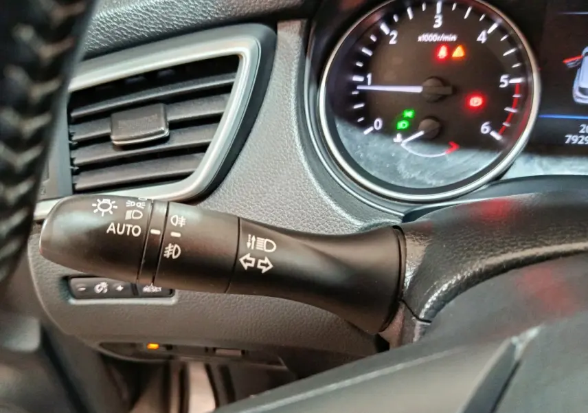 Gros plan sur la manette de commande des phares et clignotants côté gauche du tableau de bord du Nissan Qashqai gris clair 2019.