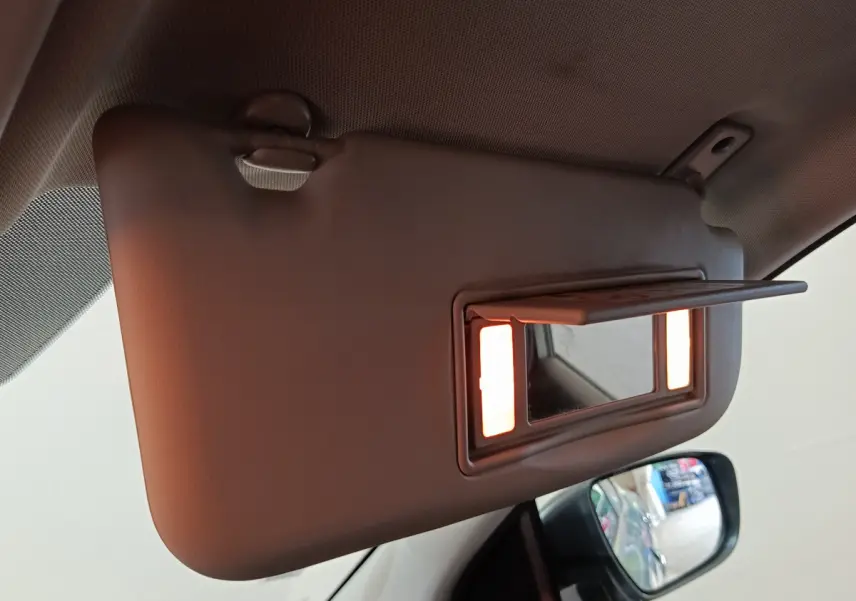 Détail du pare-soleil côté conducteur avec miroir éclairé dans un Nissan Qashqai gris clair 2019.