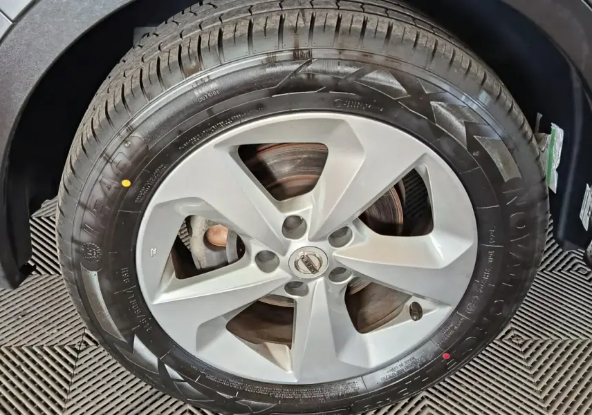 Gros plan sur la roue avant droite avec jante alliage argentée du Nissan Qashqai gris clair 2019.