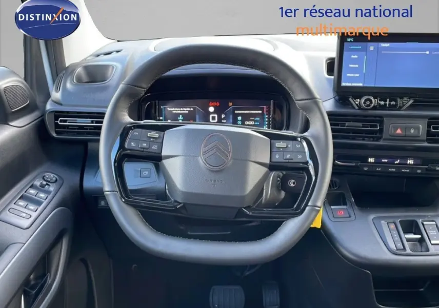 Vue intérieure centrée sur le volant cuir du Citroën Berlingo blanc glacier 2025 avec tableau de bord numérique et écran tactile.